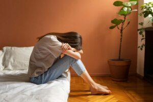donna triste sul letto